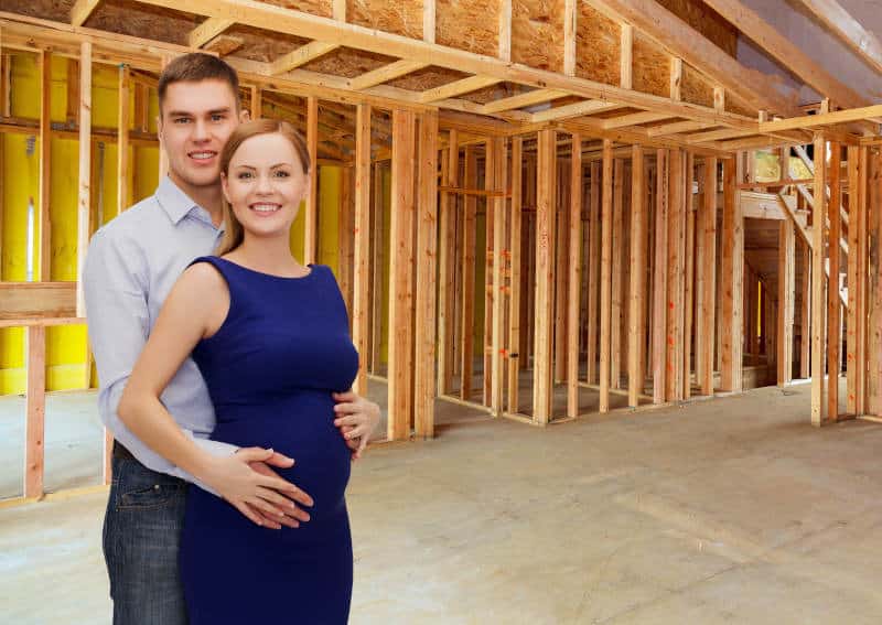 pregnant couple in from of home renovation